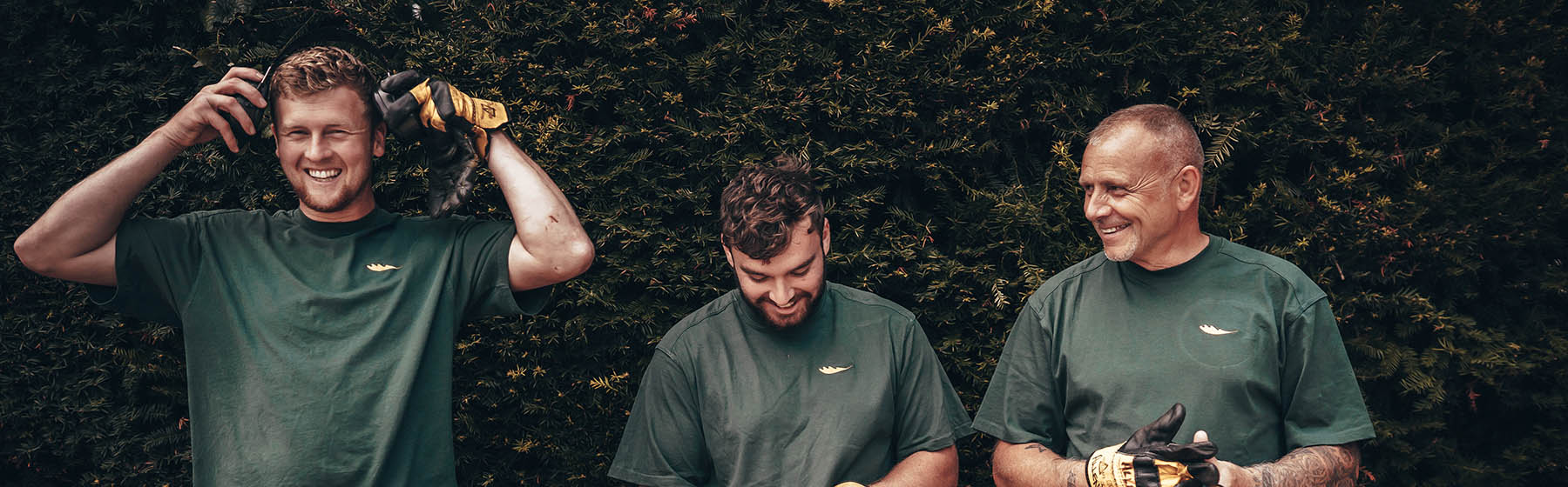 gardeners in front of a hedge